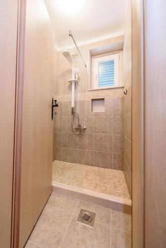 a bathroom with a shower with a glass door at Apartments Kate in Brela