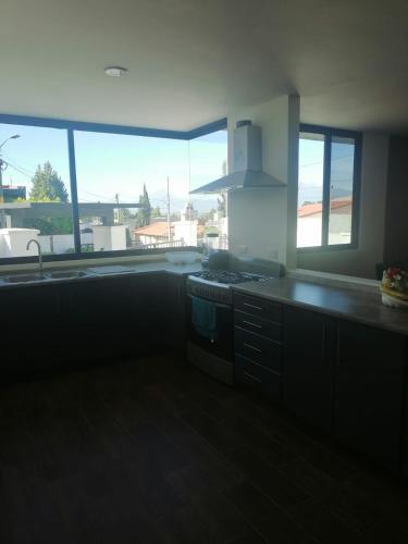 a kitchen with large windows and a stove top oven at PRECIOSA CASA NUEVA UNA PLANTA NAMASTE 