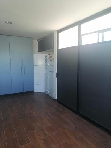 an empty room with white cabinets and a refrigerator at PRECIOSA CASA NUEVA UNA PLANTA NAMASTE 