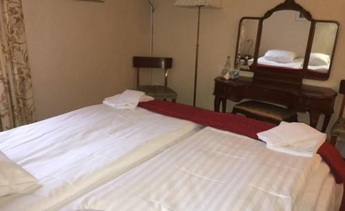 a bedroom with a bed with a mirror and a piano at Hotell Blå Blom in Gustavsberg