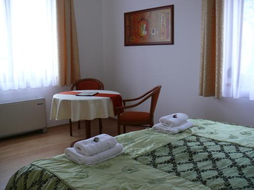 A bed or beds in a room at Szerencsemák Panzió