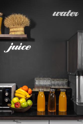 a counter with a bowl of fruit and juice at Thomas Albert Hotel in Chişinău