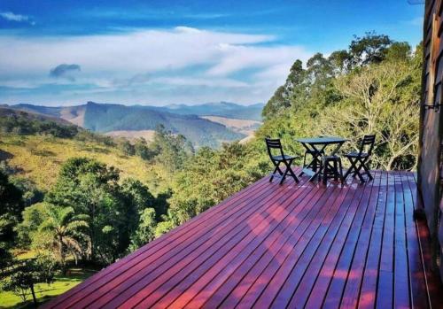 een tafel en stoelen op een terras met uitzicht bij Tao da Serra - cabana em meio à natureza! in São Francisco Xavier