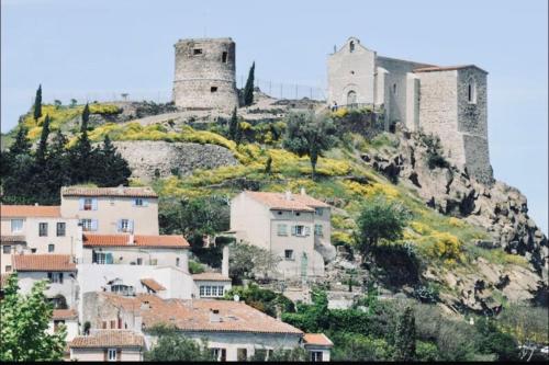 um grupo de edifícios numa colina com duas torres em Appartement T2 - 4 couchages em La Garde