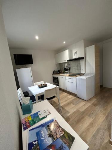 uma pequena cozinha com uma mesa e uma mesa branca sidx sidx sidx em Appartement T2 - 4 couchages em La Garde