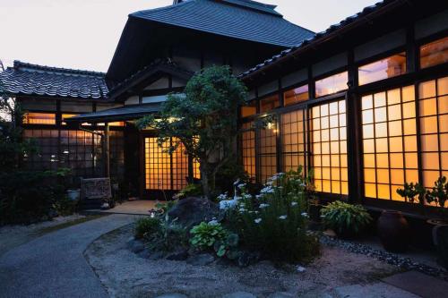a building with a garden in front of it at An old house with a fire pit for rent Guesthouse Yukarian - Vacation STAY 87627v in Egita