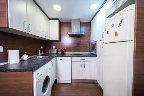a kitchen with white cabinets and a sink and a dishwasher at Singular apartamento en Delicias by beBalmy in Madrid
