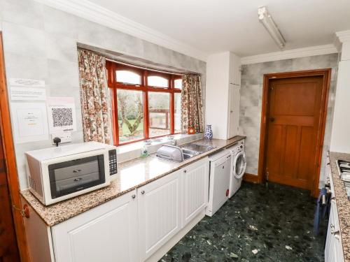 a kitchen with a sink and a microwave at Pringles Orchard in Gildingwells
