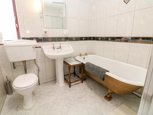 a bathroom with a tub and a toilet and a sink at Pringles Orchard in Gildingwells