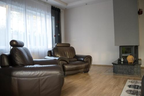 a living room with a leather couch and a chair at Māja Rubeņi in Jūrmala