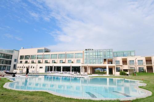 a large building with a large pool in front of it at Pisa Tower Plaza in Pisa