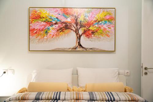 a painting of a tree on a wall above a bed at Όμορφη μονοκατοικία με 2 υπνοδωμάτια και τζάκι in Nafpaktos