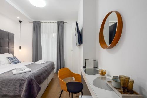 a bedroom with a bed and a mirror and a sink at Finn Luxury Suites in Split