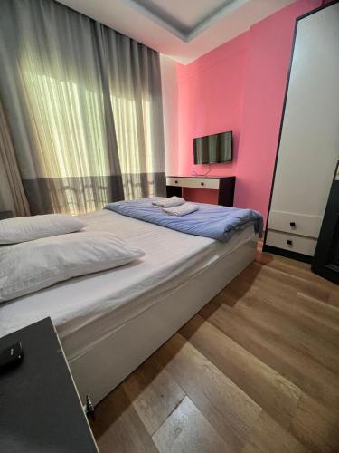 Çiftlikköy的住宿－İmperium，一间卧室设有两张床和粉红色的墙壁