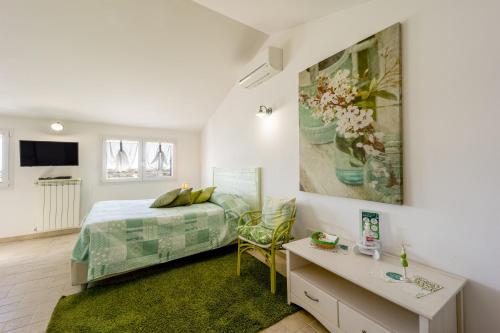 ディアーノ・マリーナにあるAgriturismo Le Girandoleのベッドルーム1室(ベッド1台付)が備わります。壁には絵画が飾られています。
