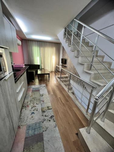 sala de estar con escalera y piano en İmperium, en Çiftlikköy