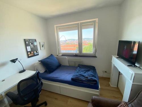 um quarto com uma cama, uma secretária e uma janela em Bamberg auf einen Blick - Gemütliches Zimmer in der geteilten Wohnung eines freundlichen Paares em Bamberg