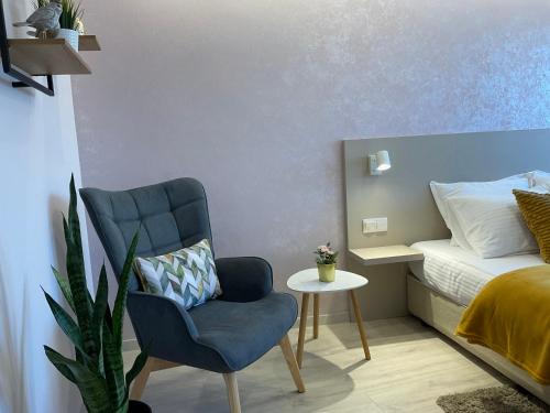 a bedroom with a blue chair and a bed at Guest Rooms Tsarevets in Veliko Tŭrnovo