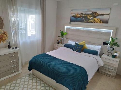 1 dormitorio con 1 cama con edredón azul y blanco en Detached Villa With Private Pool Torrevieja en Torrevieja