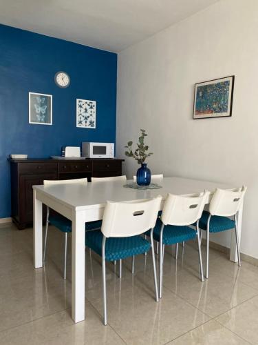 a dining room with a white table and chairs at Sea You Soon! in Netanya