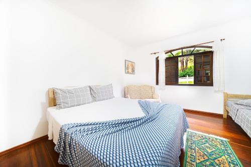 a white bedroom with a bed and a window at Hotel Pousada Casa Grande in Joanópolis