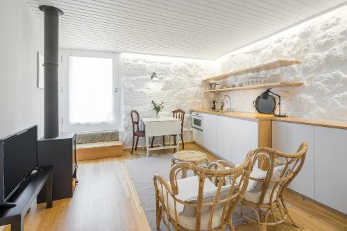 a kitchen and dining room with a table and chairs at Casas Rossio by Casas com Estória Boutique Houses in Santa Comba Dão
