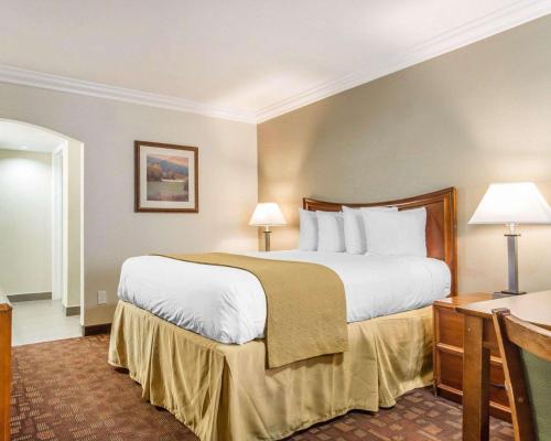 una camera d'albergo con un grande letto e una scrivania di Quality Inn Sacramento a Sacramento