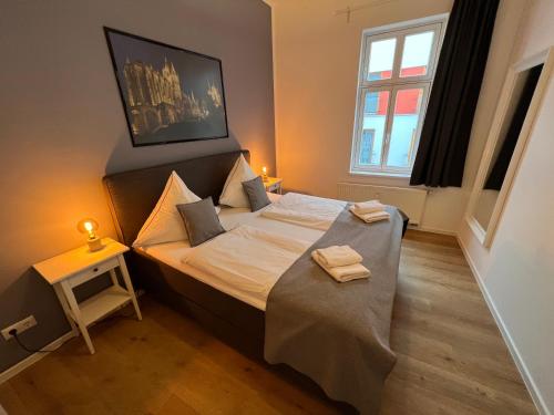 a small bedroom with a bed with two towels on it at Altstadt Apartment Erfurt in Erfurt