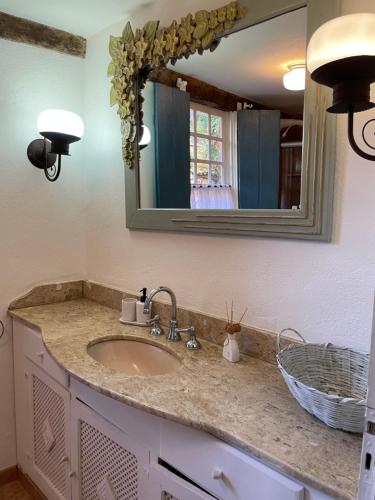 um balcão de casa de banho com um lavatório e um espelho em Casa Divinas em Tiradentes