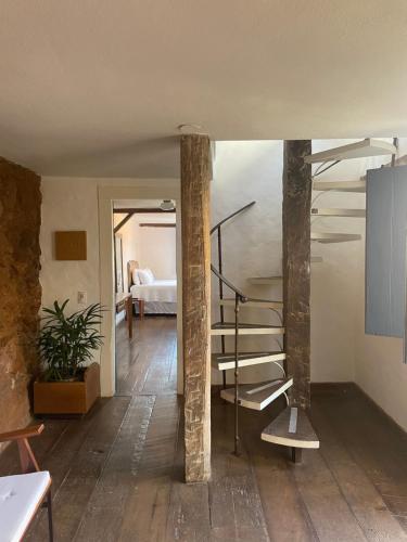 a spiral staircase in a room with a bedroom at Casa Divinas in Tiradentes
