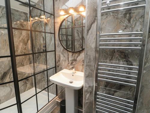 a bathroom with a sink and a shower at The Wizard's Loft in Alnwick