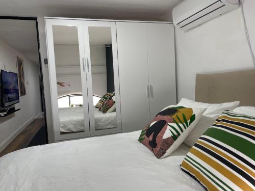 a bedroom with a white bed and a mirror at A new Jaffa gallery apartment a minute from the beach and entertainment centers in Tel Aviv