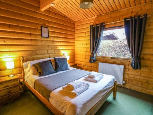 a bedroom with a bed in a log cabin at Valley View in Rhayader