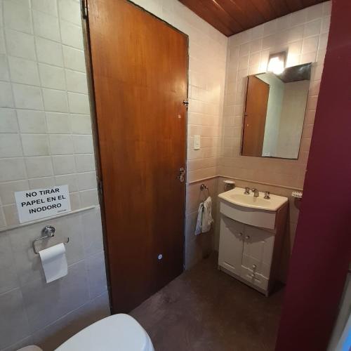 een badkamer met een toilet, een wastafel en een spiegel bij Increíble casa a 4 cuadras del mar in Mar del Plata