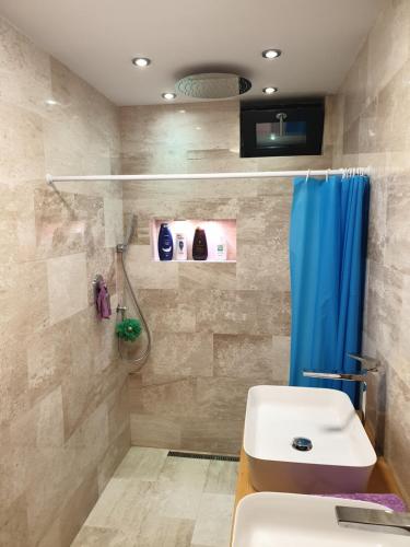 a bathroom with a sink and a shower and a toilet at Panorama penthouse in Şelimbăr