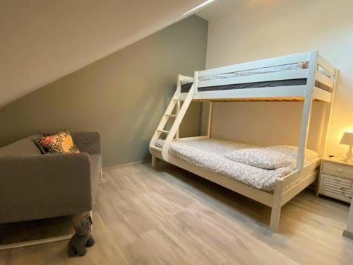 a childs bedroom with a bunk bed and a couch at La Maison de J. in Chaumont