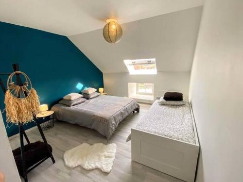 een slaapkamer met een bed en een blauwe muur bij La Maison de J. in Chaumont
