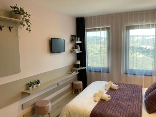 a bedroom with a bed and a tv on the wall at Guest Rooms Tsarevets in Veliko Tŭrnovo