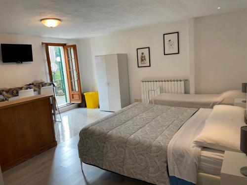 a bedroom with two beds and a television in it at L'ulivo in Levanto