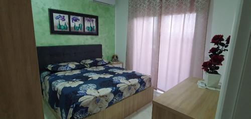 - une chambre avec un lit et une couette bleue et blanche dans l'établissement luka apartament, à Shëngjin