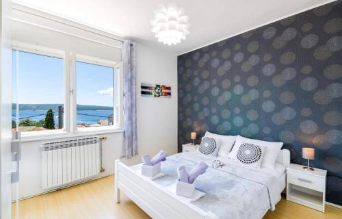 - une chambre avec un grand lit et une grande fenêtre dans l'établissement Apartments Tatjana Crikvenica, à Crikvenica