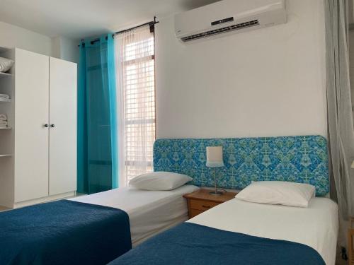 two beds in a room with blue and white at Sea You Soon! in Netanya