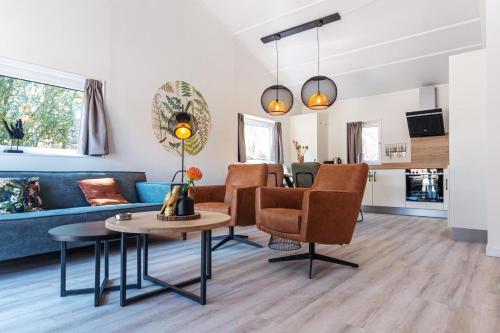 a living room with a blue couch and a table at Nesserduinen in Nes