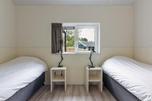 2 camas individuales en una habitación con ventana en Nesserduinen en Nes