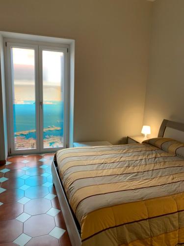 een slaapkamer met een bed en een groot raam bij Vesuvio House in Boscoreale