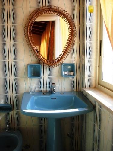 a bathroom with a blue sink and a mirror at Case Vacanze Arcobaleno in Lipari