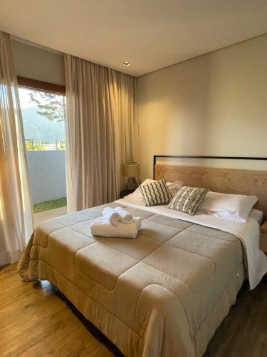 una camera da letto con un letto grande con due asciugamani sopra di Casa 09 Monte Boa Vista - Refúgio com Piscina Privativa, Sauna e Vista das Montanhas a Teresópolis
