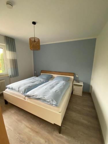 a bedroom with a bed and a pendant light at Ferienwohnungen Schierbaum in Lembruch