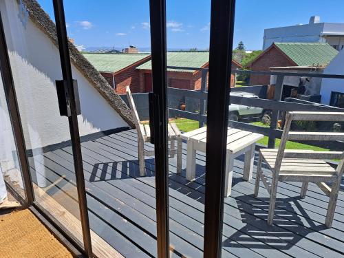 a balcony with a chair and a table at StarFish Accommodation in Struisbaai