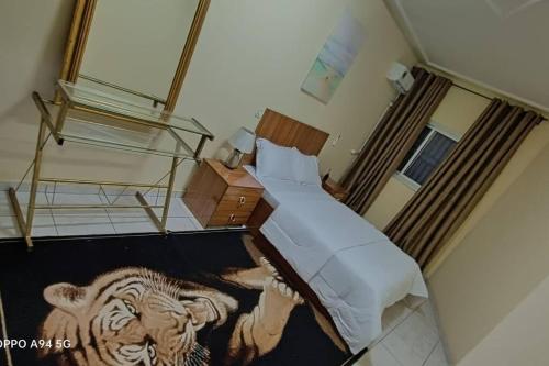 - une chambre avec un lit avec un tigre peint au sol dans l'établissement Grace Apart Bastos Yaoundé, à Yaoundé